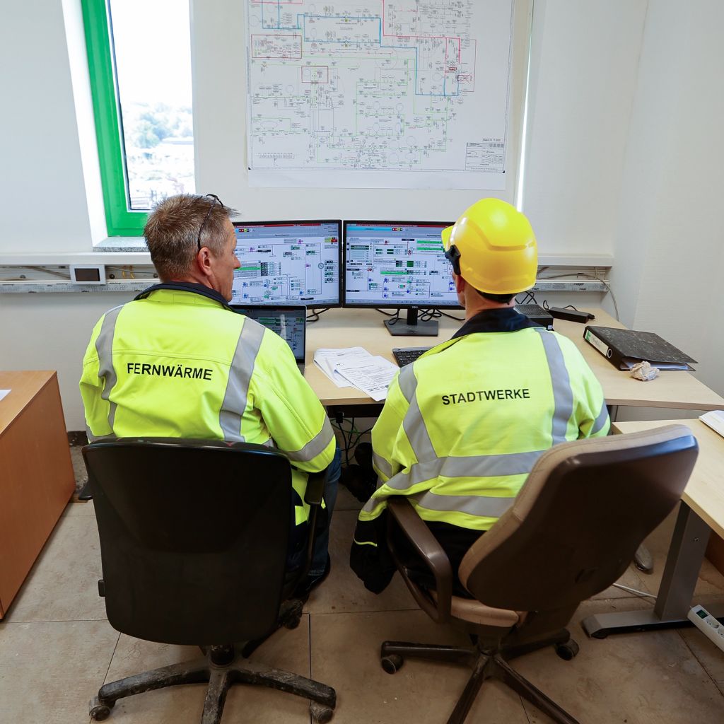 Zwei mitarbeiter der Stadtwerke und Fernwärme sitzen vor Computerbildschirmen